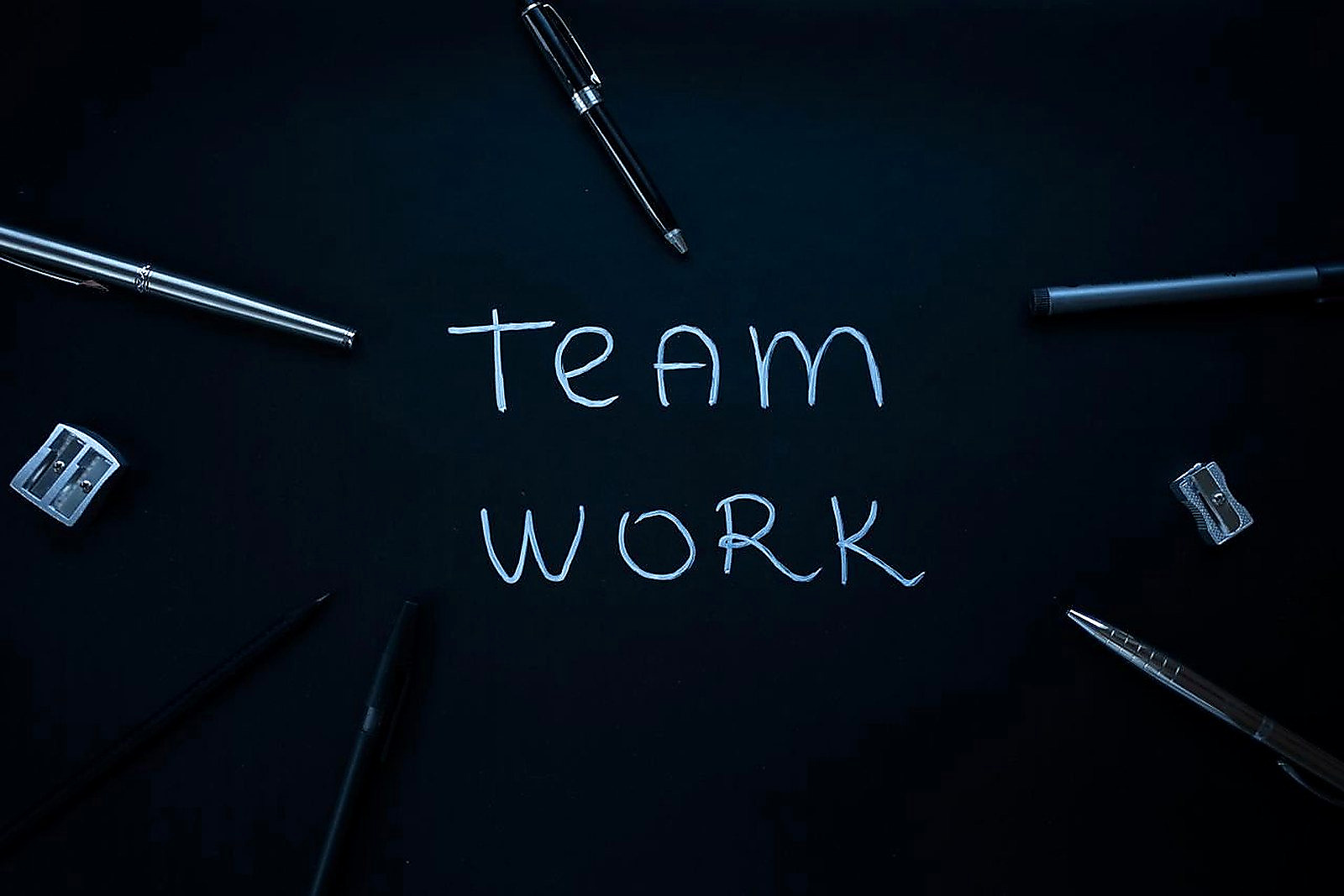 Free Arrangement of office supplies around teamwork text on black background. Stock Photo