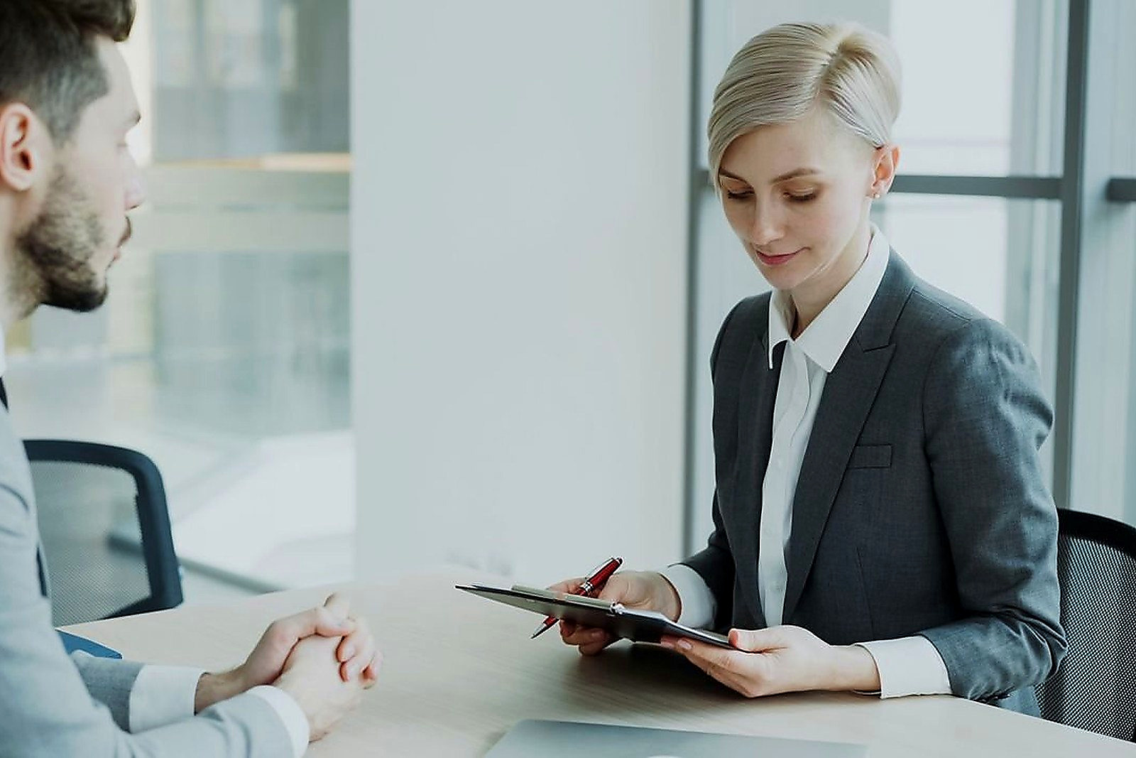 Free Two professionals in a modern office discussing business. Bright, professional setting. Stock Photo